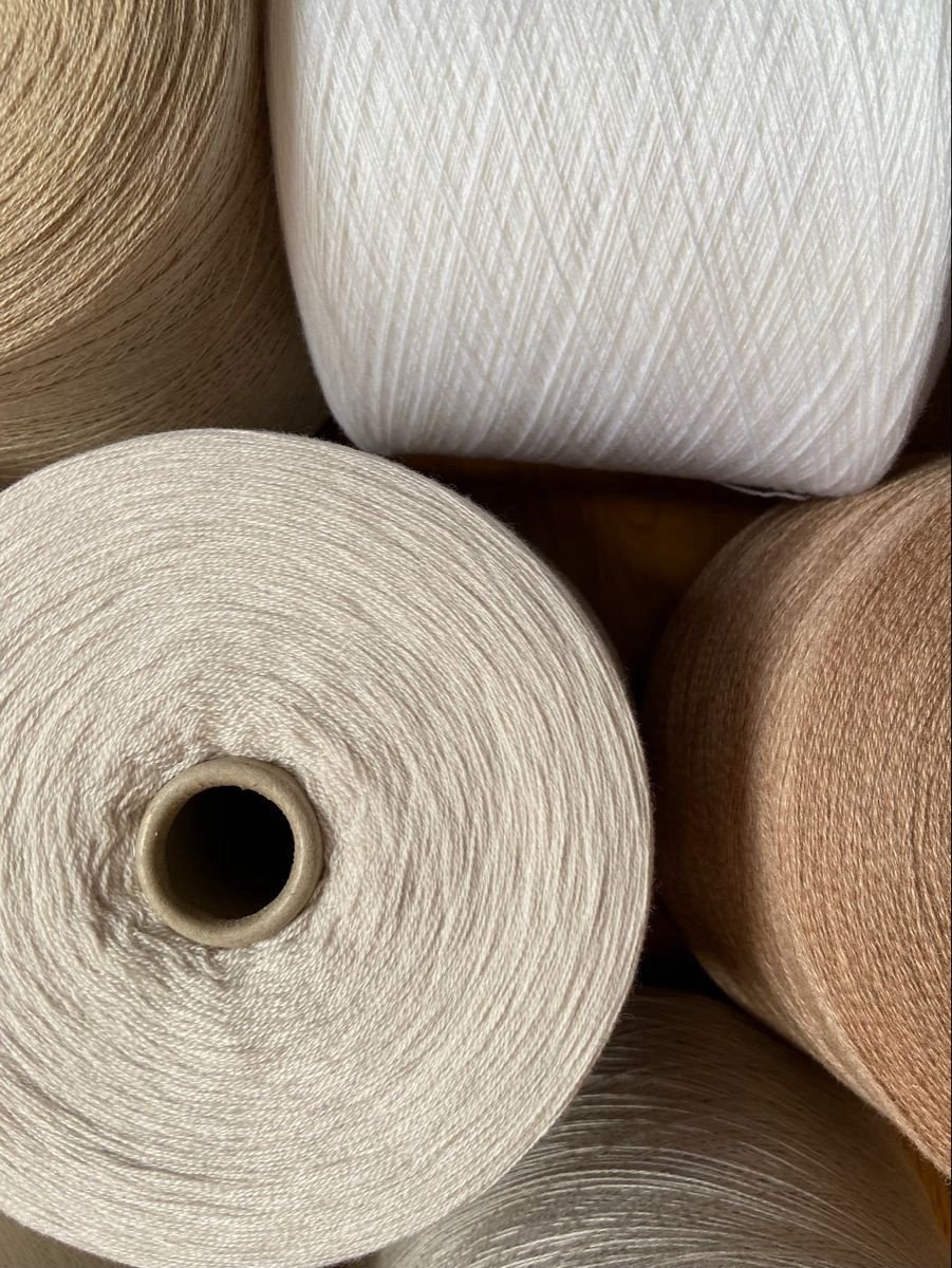 Cones of fine cashmere and natural fibre yarn
